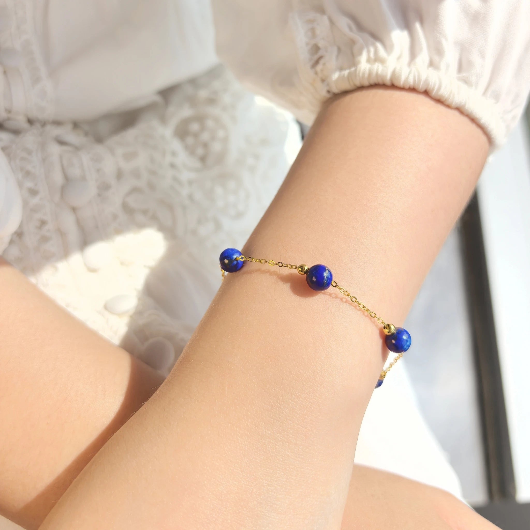 Female wearing dainty Milky Way Stroll Lapis Lazuli Bracelet on wrist, elegant deep blue crystal everyday adjustable jewelry
