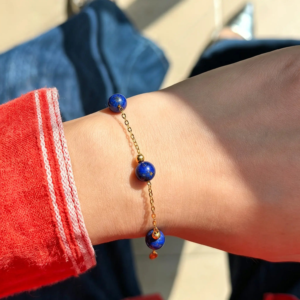 Milky Way Stroll bracelet with blue lapis lazuli beads on a gold-tone chain worn on a wrist.