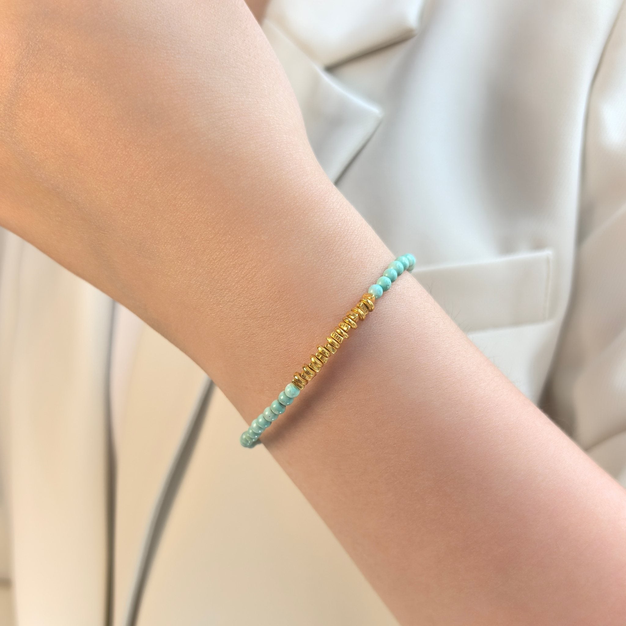 Woman wearing Calm Tide turquoise chip gold bracelet on wrist, intuitive crystal jewelry