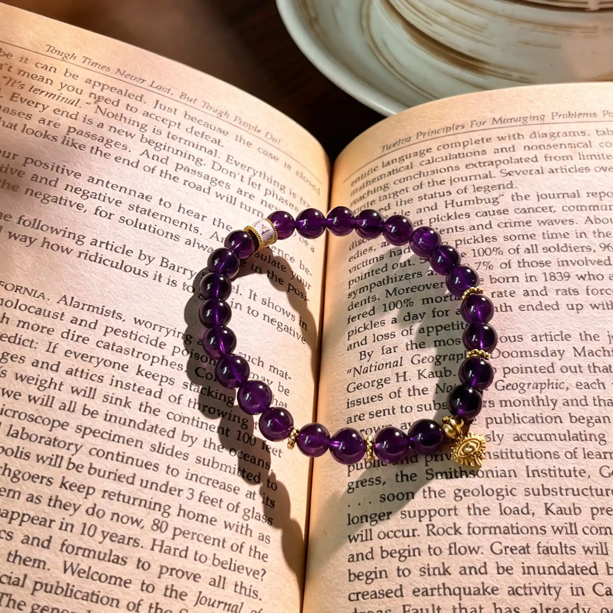 Amethyst evil eye protection bracelet lying on a book.