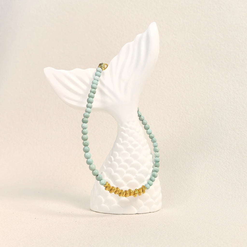 Ins coastal aesthetic flat lay of Calm Tide turquoise chip bracelet with white mermaid tail decor, natural pale turquoise bracelet for daily wear.