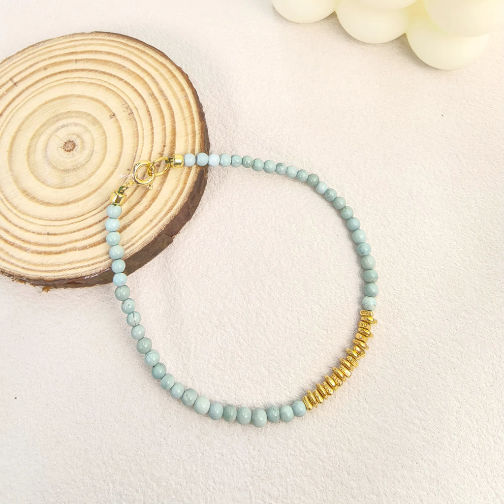 Ins coastal aesthetic flat lay of Calm Tide turquoise chip bracelet with white mermaid tail decor, spiritual talisman gift for women