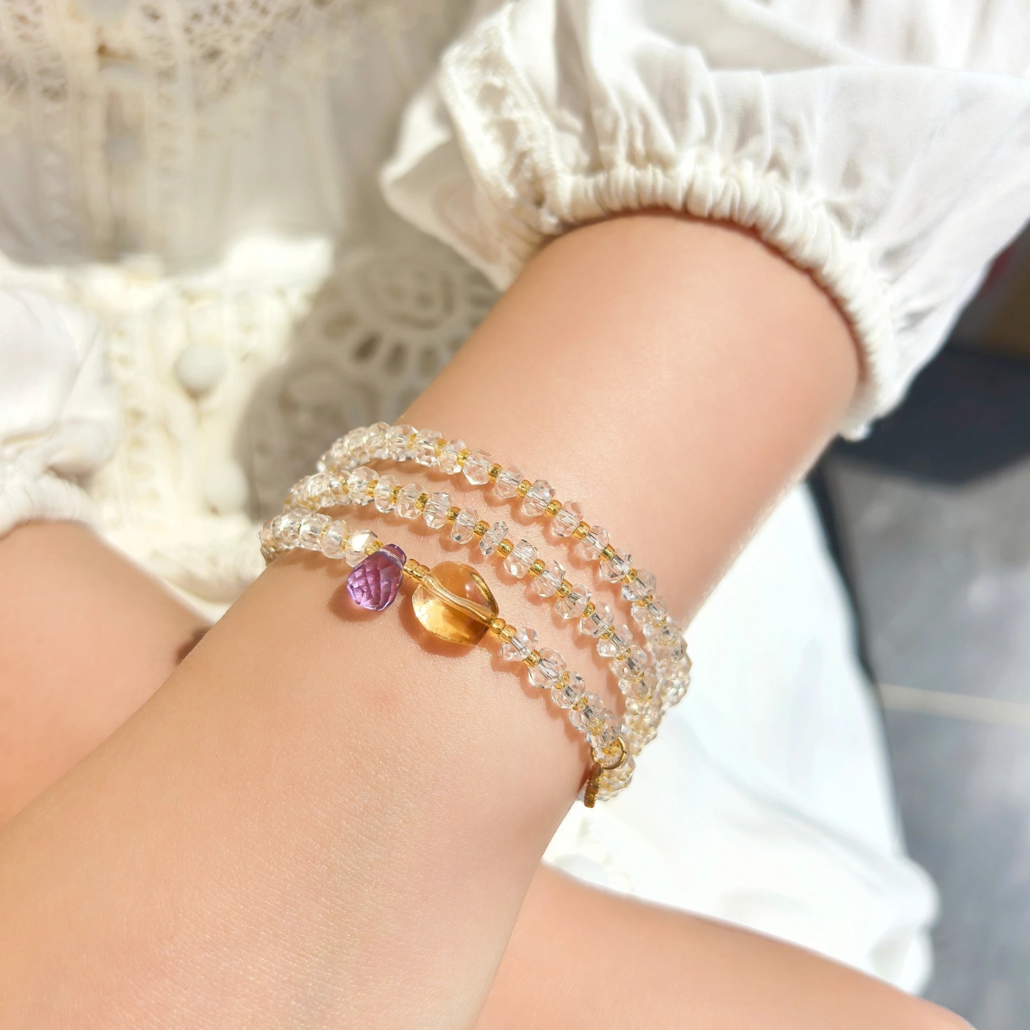 Close up of Three Graces clear quartz wrap bracelet faceted crystal beads citrine amethyst detail