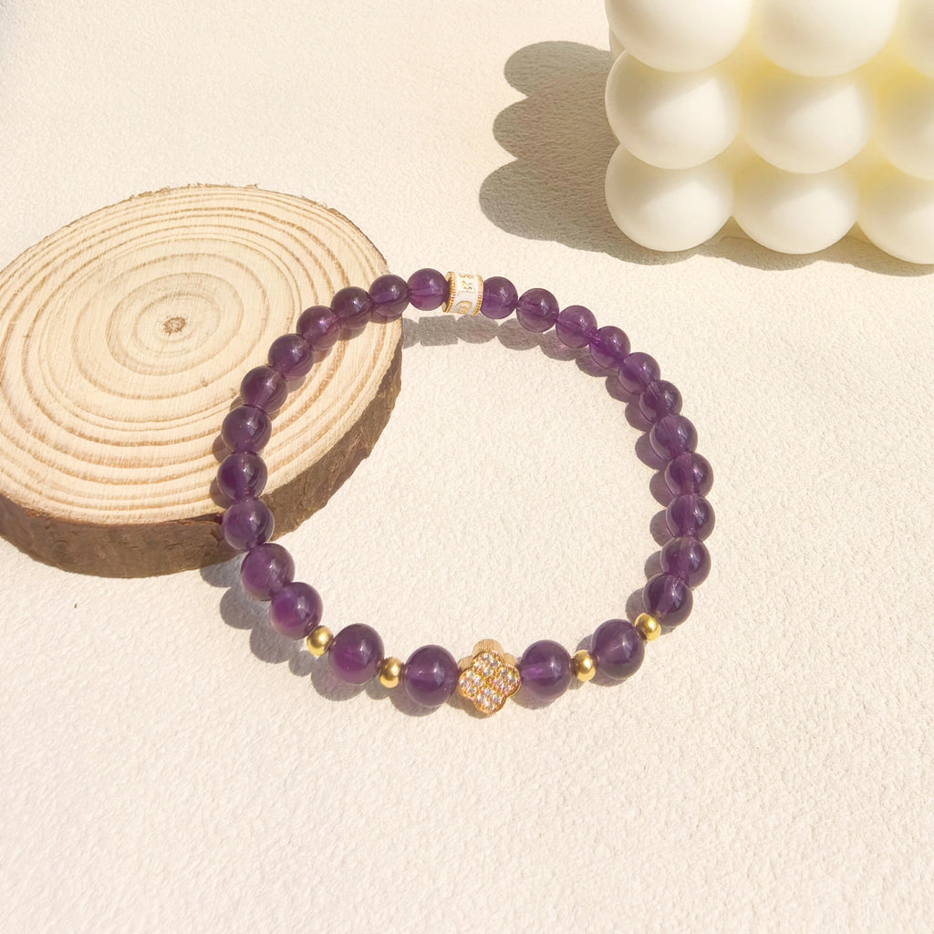 Soft ins style still life shot of Amethyst Lucky Clover Mantra Bracelet, elegant purple crystal spiritual jewelry decor for witchy feminine aesthetic