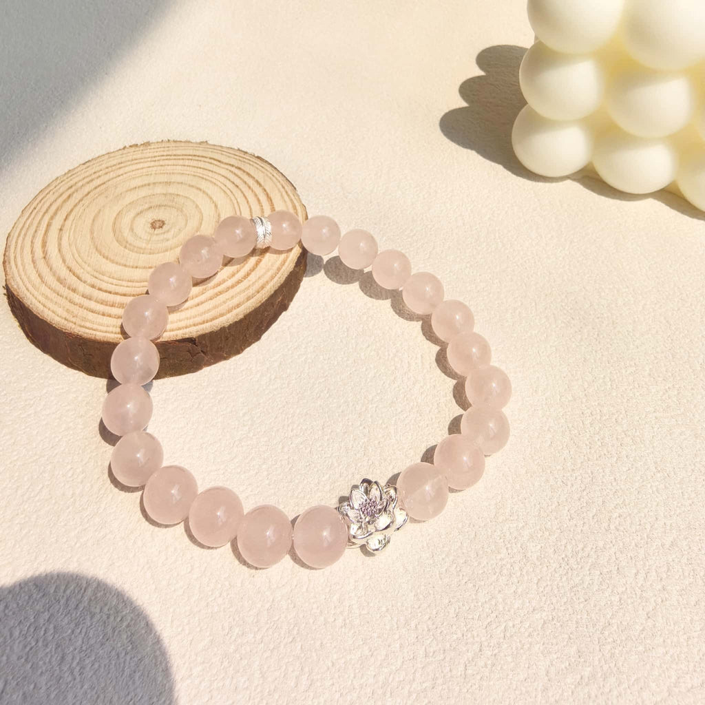 Ins aesthetic still life of Lotus Emotion Renewal Rose Quartz Bracelet with candle and wood, gentle healing crystal jewelry for women