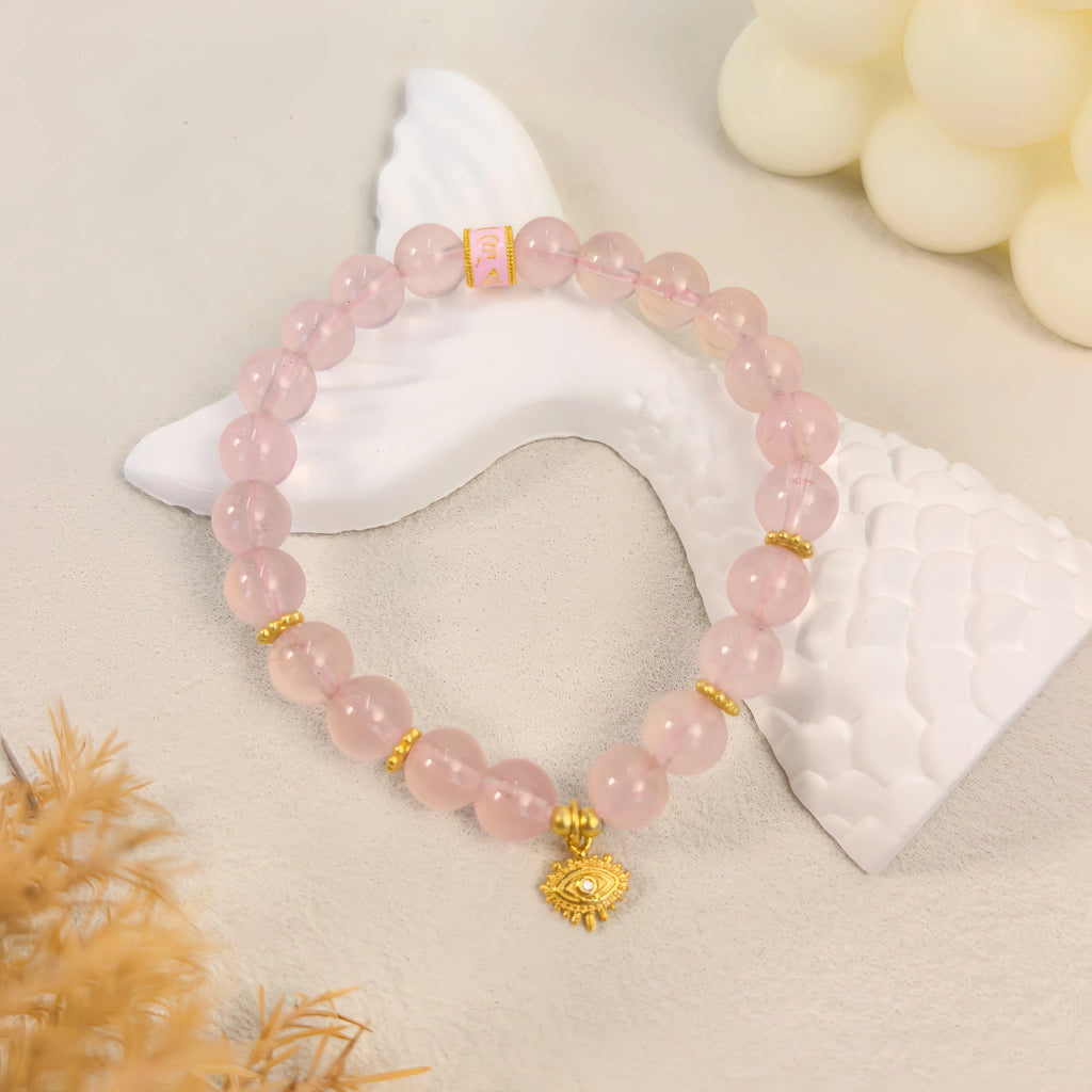 Cozy ins still life styling of pink aura evil eye protection crystal bracelet with dried grass and cream candles, spiritual crystal jewelry decor