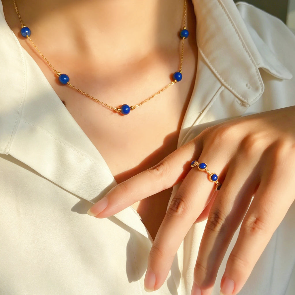 Woman wearing Milky Way Stroll lapis lazuli gold necklace and ring with white shirt, third eye chakra healing jewelry.