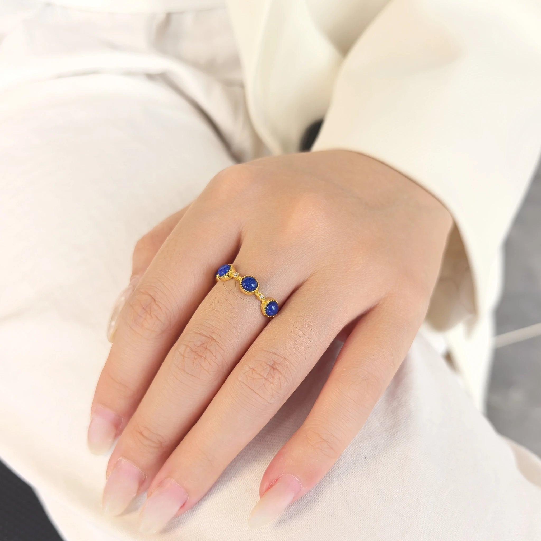 Woman wearing Milky Way Stroll lapis lazuli adjustable open band ring on finger, minimalist blue crystal stacking jewelry