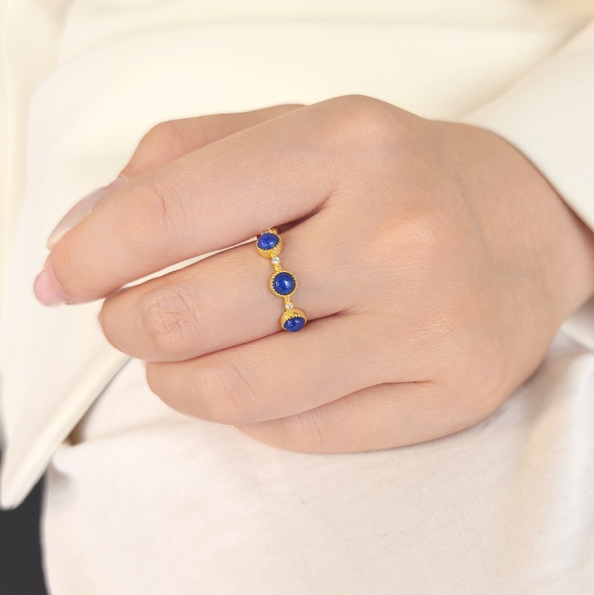 Woman wearing Milky Way Stroll lapis lazuli adjustable open band ring on finger, minimalist blue crystal stacking jewelry