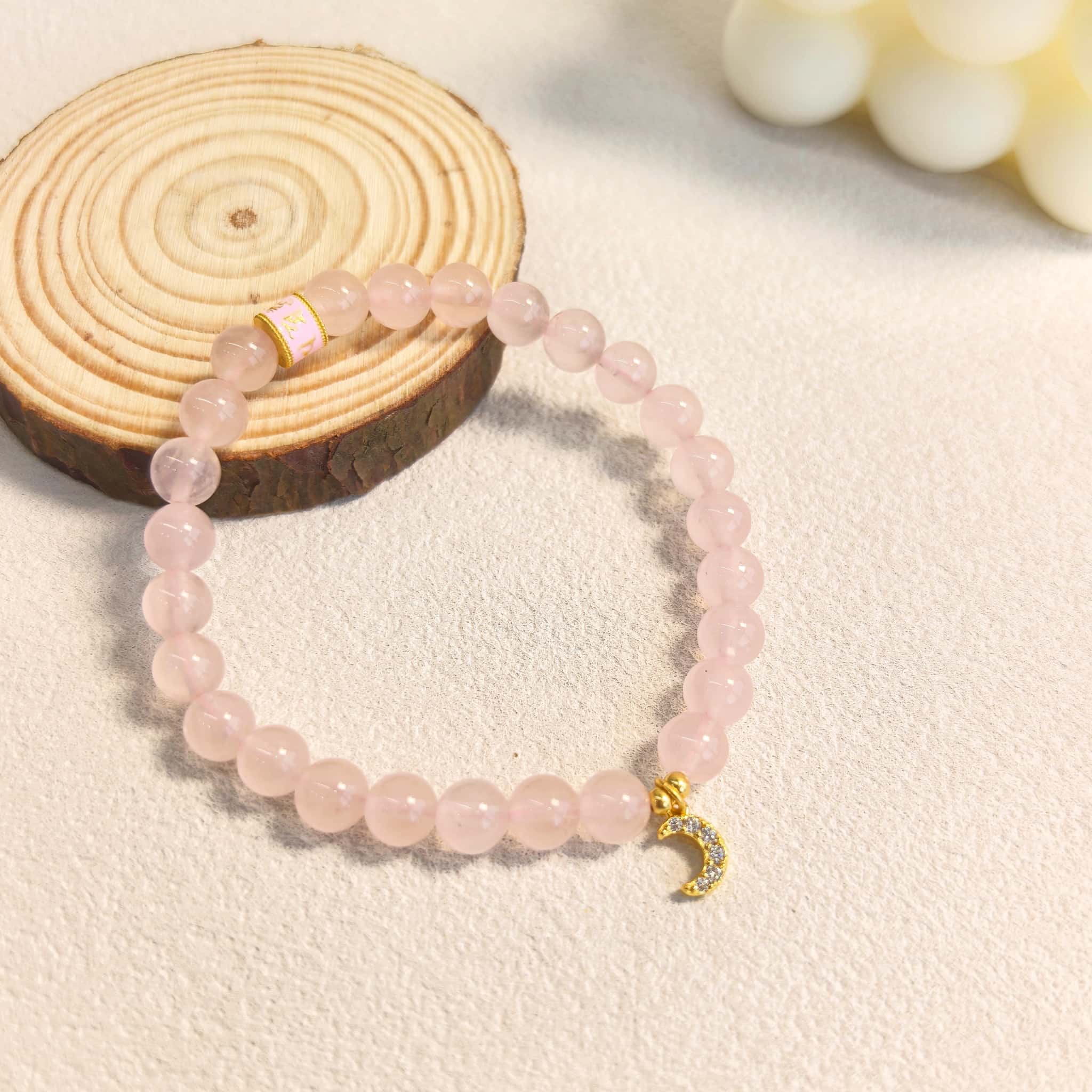 Side angle of witchy rose quartz crescent moon healing bracelet, positive energy love crystal spiritual jewelry gift