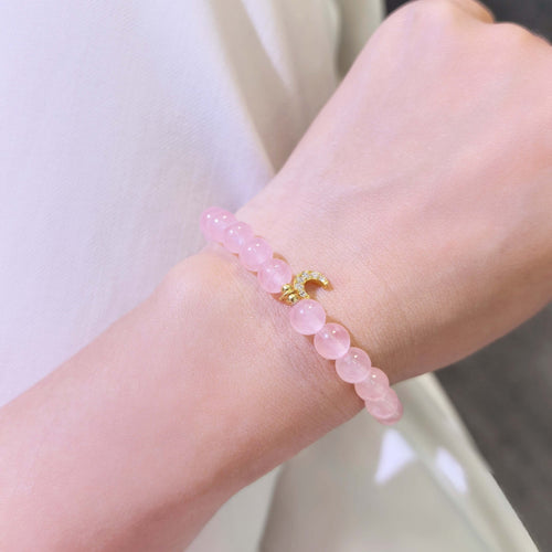 Women wearing dainty rose quartz crescent moon charm bracelet, everyday stackable witchy crystal jewelry