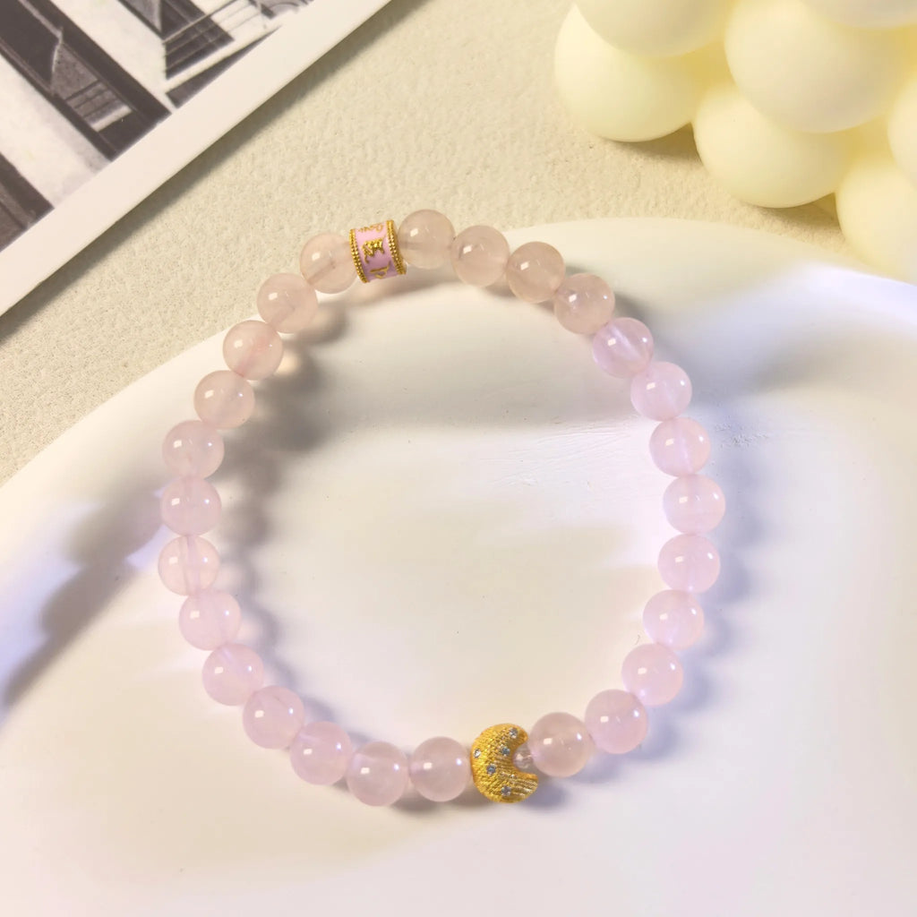 Top view of gold-plated crescent moon charm on Self-Love Lunar Mantra Rose Quartz Bracelet