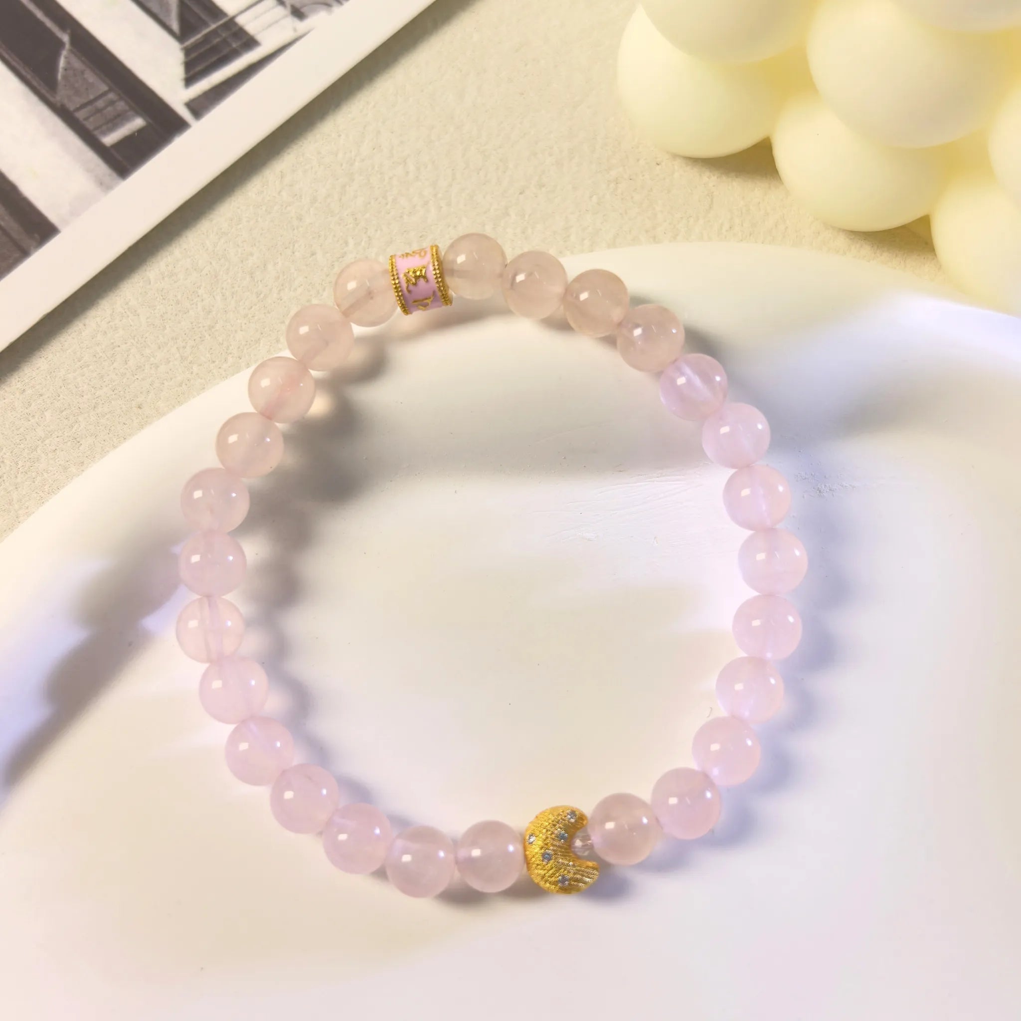 Top view of gold-plated crescent moon charm on Self-Love Lunar Mantra Rose Quartz Bracelet