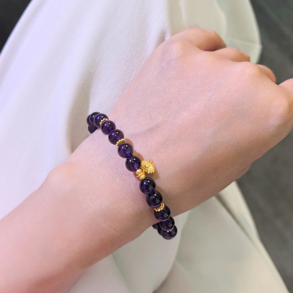 Female model wearing elegant Amethyst Aura Evil Eye Bracelet on wrist, minimalist purple aura spiritual everyday crystal accessory