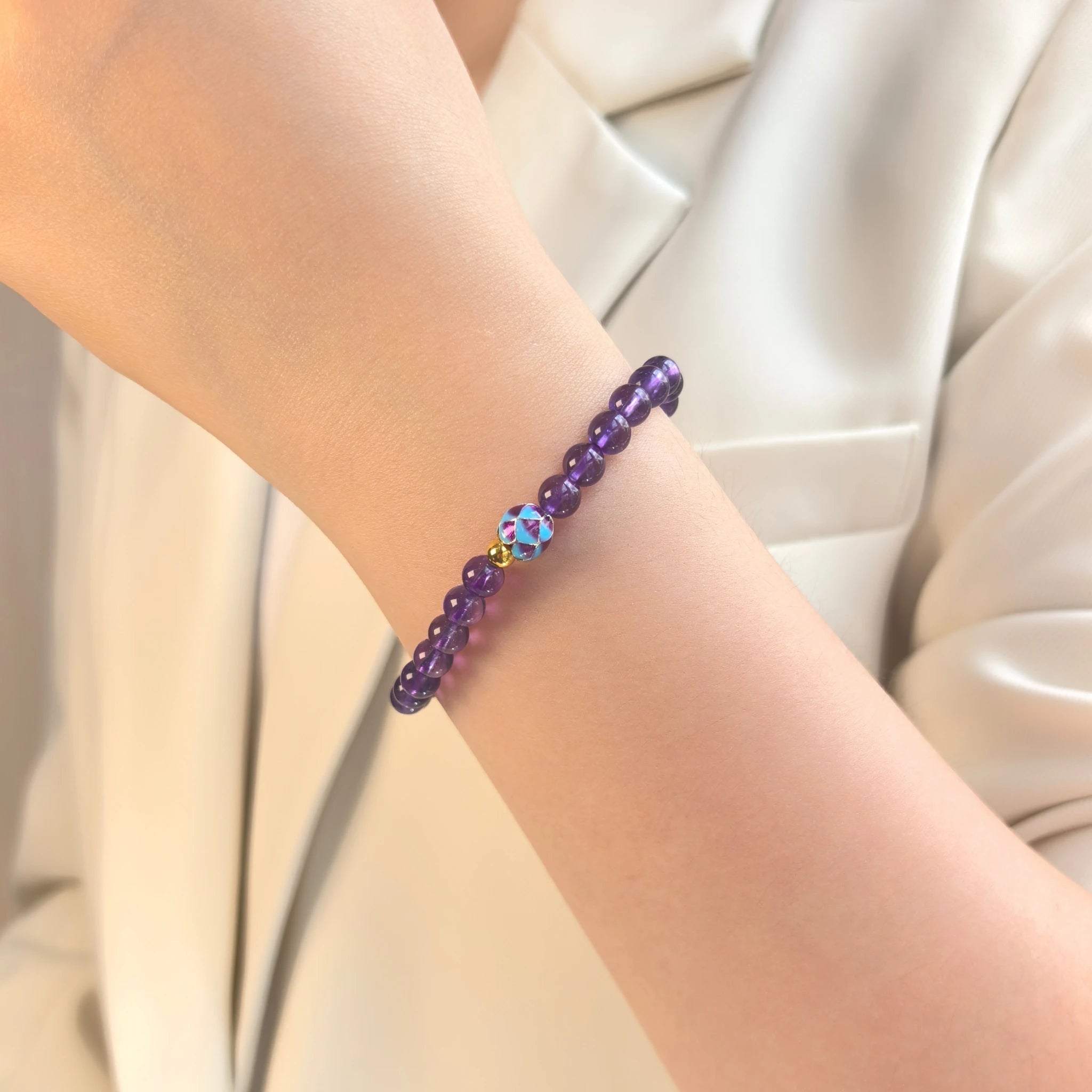 Female model wearing delicate Amethyst Lotus Bloom Bracelet on wrist, minimalist purple spiritual everyday crystal accessory